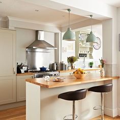 a kitchen with two stools and an island