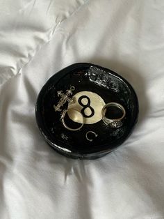 a black and white clock with the number eight in it's center on a white sheet