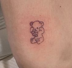 a small tattoo of a teddy bear holding a flower