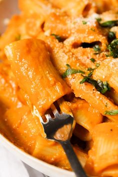 a bowl filled with pasta covered in sauce and parmesan cheese