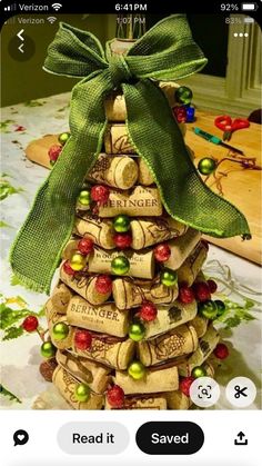 a christmas tree made out of wine corks with a green bow on the top