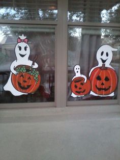 two windows decorated with pumpkins and ghost stickers