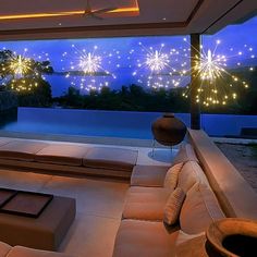 a living room filled with lots of furniture under a firework skylight at night