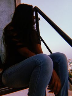 a woman sitting on top of a window sill