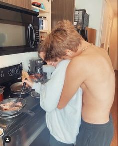 a man and woman are cooking in the kitchen with their backs turned to one another