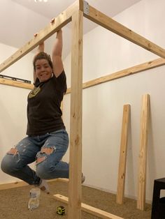 a man standing on top of a wooden structure in the middle of an unfinished room