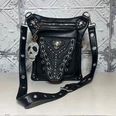 This Skull Bag Is Made From Soft High Quality Pu Leather. Accented With Silver Skull’s And Silver Grommets 11”H X 9”W. There Are 3 Compartments On The Front Of This Bag. A 5 1/2 “X 6” Wide Magnetic Button Pouch, A 8 1/2” X 7 1/2” Zipper Compartment And A 5 1/2” X 6 “ Zipper Compartment. The Back Side Has A 6 1/2” X 7 1/2” Side Pocket And A 5 1/2” X 6” Drop Pocket. Comes With An Adjustable Grommet Black Strap 19”-23”. Double Sided Crystal Skull Keychain Comes With Bag! Fancy Handbags, Button Pouch, Skull Bags, Skull Keychain, Crystal Skull, Side Pocket, Pu Leather, Crossbody Bag, Double Sided