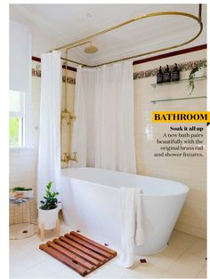 a white bath tub sitting in a bathroom next to a shower curtain and potted plant