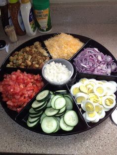 an assortment of vegetables arranged in a circle on a counter top with condiments