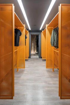 the yellow lockers are lined up against the wall and on the floor, with shirts hanging in them