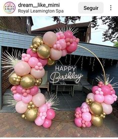 balloons are arranged in the shape of an arch with gold and pink decorations on it