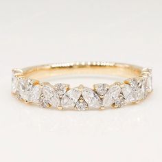 a yellow gold ring with five pear shaped diamonds