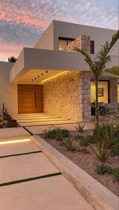 a modern house is lit up at night