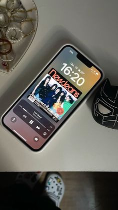 a cell phone sitting on top of a table next to a mask