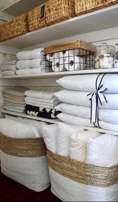 stacks of white linens and baskets on shelves