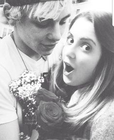 a young man holding a bouquet of flowers next to a woman with her mouth open