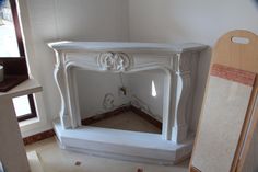 a white fireplace with a mirror on the wall