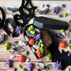 halloween decorations are laid out on a wooden table with a black box and knife next to it