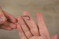 a person holding a tiny object in their left hand, with the string attached to it