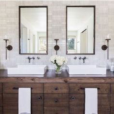 a bathroom with two sinks and mirrors on the wall