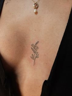 a woman's chest with a flower tattoo on the left side of her stomach