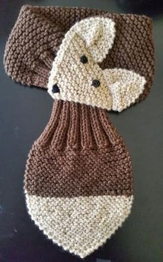 a crocheted brown and white tie on top of a table