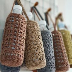 crocheted coffee cups hanging from hooks on the wall