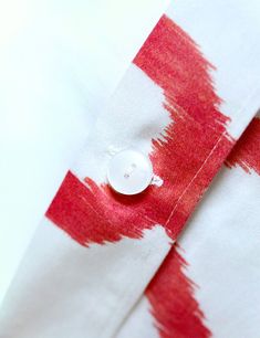 a button on a red and white shirt