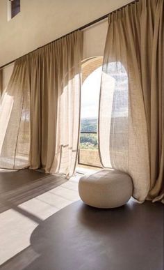 a room with large windows and curtains in it