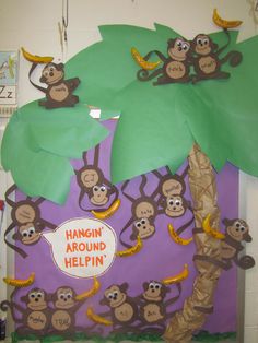 a bulletin board with monkeys on it and bananas hanging from the tree in front of them