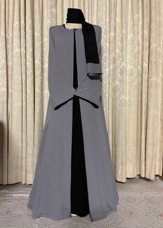 Gray and black abaya burqa 3-piece set with matching hijab/scarf in high quality fabric, summer friendly, and suitable for all weather conditions.  Abaya gray upper cape and hijab is handmade in soft, lightweight, breathable abaya fabric pipened with rich black borders matching under abaya, front open with single button neck closure. Black under abaya is handmade in super soft cotton linen fabric, full sleeved with zippered side pockets and pearl neck button.  Abaya cape and under abaya are detachable, may be worn together or separately, as per choice. Super soft cloth and a simple stylish look. Available in size 52. Black Long Abaya With Dabka Detailing, Elegant Long Black Niqab, Elegant Black Maxi Khimar, Elegant Black Maxi Length Khimar, Formal Black Abaya With Dabka, Black Maxi Length Sets For Eid, Layer Abaya, Abaya Cape, Abaya Fabric