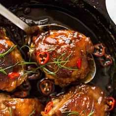 some meat with sauce and peppers in a skillet