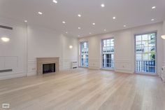 an empty living room with white walls and wood floors