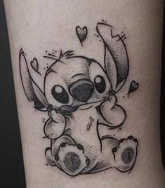 a small tattoo of a cartoon character with hearts on it's leg and an arrow in the shape of a heart