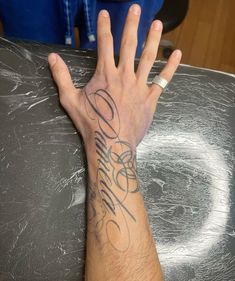 a person with their hand on top of a metal table that has writing on it