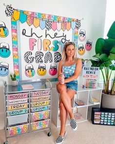 a woman sitting on top of a metal rack in front of a wall covered with posters