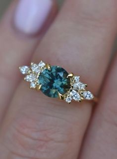 a woman's hand holding a blue and white diamond ring