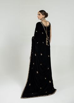 Nothing Is More Magical Than A Pure Black Velvet Attire Embellished With Zardozi, Nakshi, Dabka, Mukesh, Sequins And Resham On The Neckline, Shoulders, Borders Of The Shirt, And A Fully Worked Back. The Ensemble Is Paired With Black Flared Pants And A Handworked Shawl To Bring Out The Feminity In You. Black Dabka Dupatta For Reception, Black Dupatta With Dabka For Reception, Elegant Dabka Saree For Reception, Black Embellished Formal Traditional Wear, Traditional Black Embellished Saree, Black Embellished Saree For Eid, Black Embellished Dupatta With Traditional Drape, Traditional Formal Embellished Saree, Anarkali Cutdana Dupatta For Evening