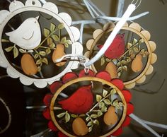 two wooden ornaments with birds and fruit on them