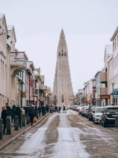 people walking down the street in front of a tall building