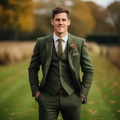 a man wearing a suit and tie standing in the grass