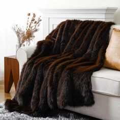 a white couch with a brown and black blanket on it