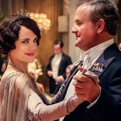 a man and woman dancing together in formal wear