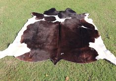 a cowhide rug is laying on the grass