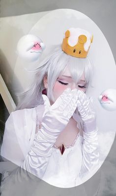 a woman with white hair wearing a tiara and holding her hands to her face