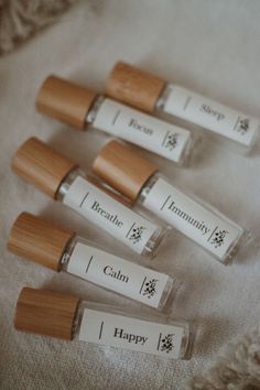 four lip bales sitting on top of a white cloth next to a bottle of toothpaste