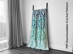 a blue and white blanket sitting on top of a wooden floor next to a window