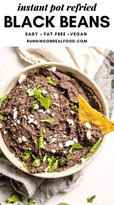 a white bowl filled with black beans and tortilla chips on top of a table