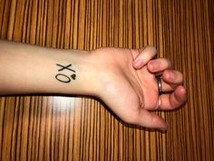 a person's arm with a tattoo on it that reads xo and has an eyeball in the middle