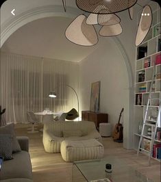 a living room filled with furniture and lots of bookshelves on top of it